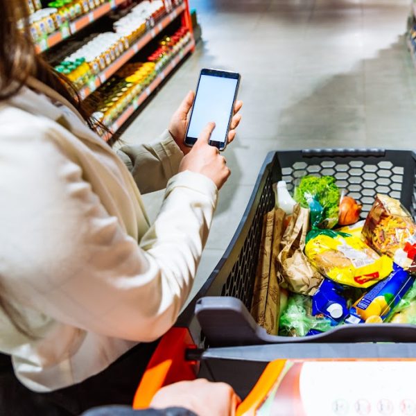 Hand holding phone at grocery checkout